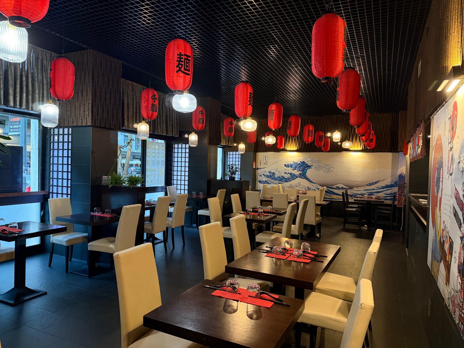 Sala interna di Sento Ramen con lanterne rosse giapponesi e murale dell'onda di Hokusai