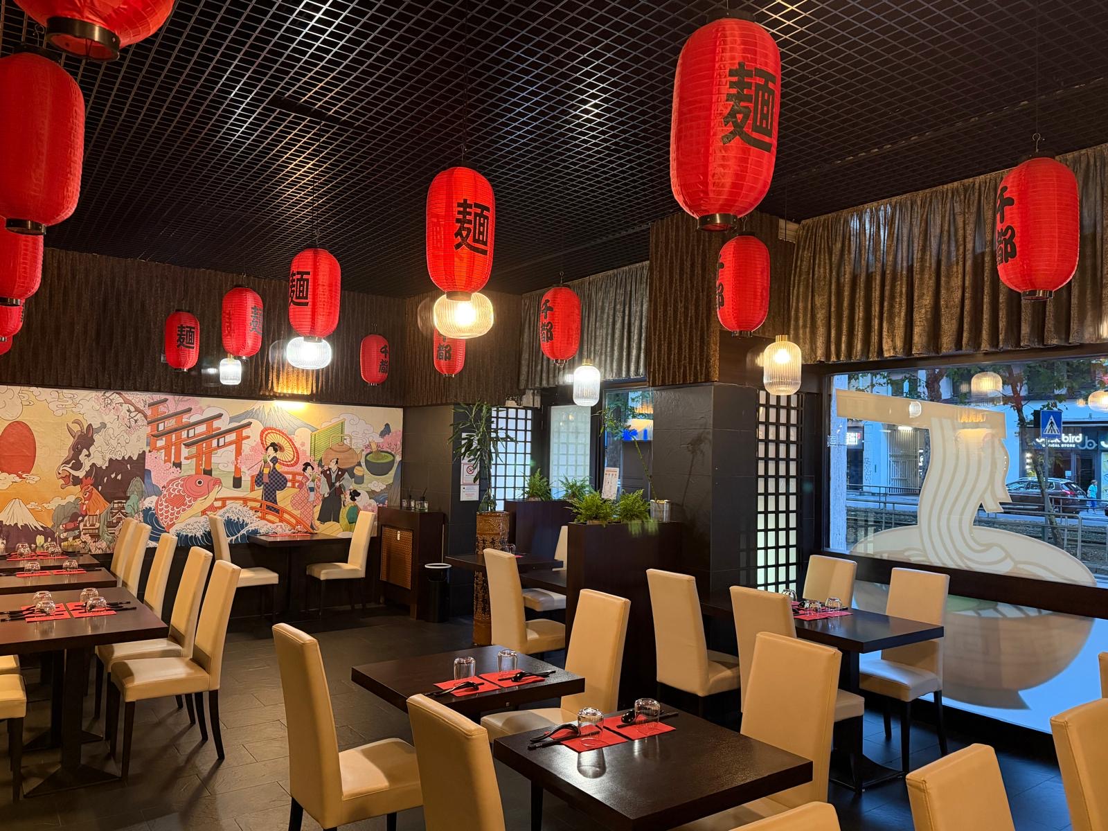 Sala di Sento Ramen con lanterne rosse e murale giapponese